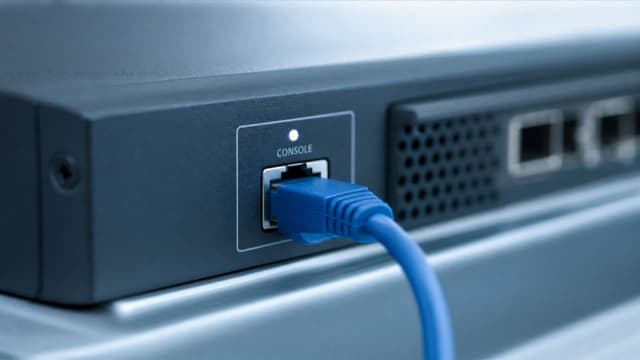 Close-up of a network device with a blue console cable connected.